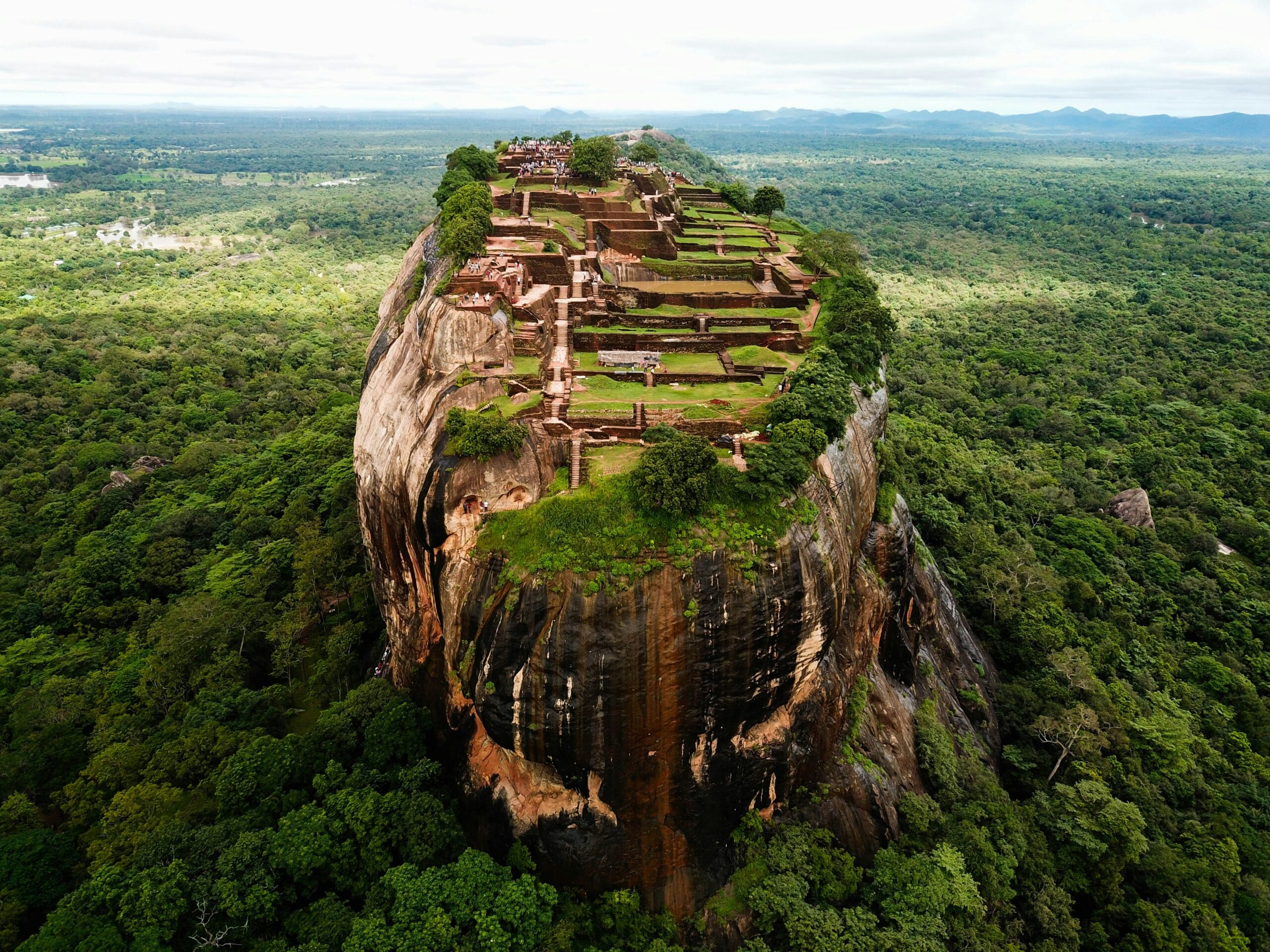 Aerial view of the ancient Sigiriya Rock Fortress surrounded by lush green jungle, a top Cultural Triangle stop on a 14-day Sri Lanka itinerary.