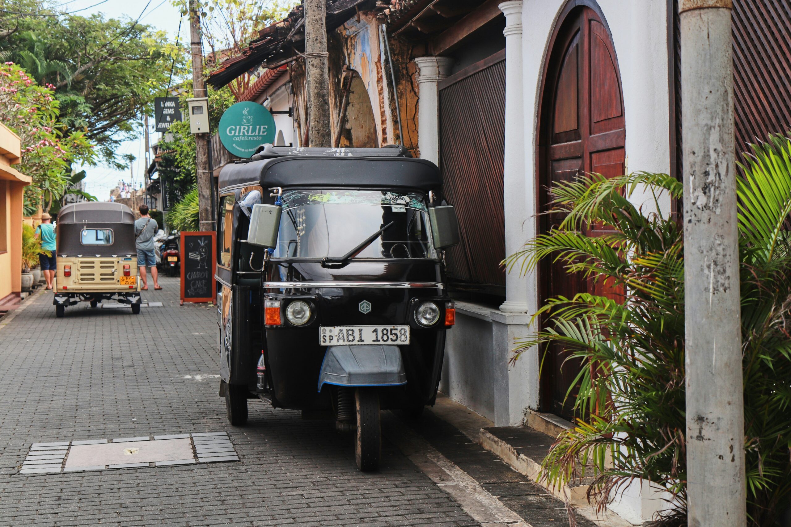A black tuk-tuk parked along a cobblestone street with colonial buildings in historic Galle Fort, Sri Lanka.